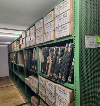 Bild eines Archivregals mit alten Dokumenten